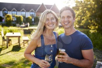 Portrait Of Couple Enjoying Outdoor Summer Drink At Pub