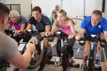 Male Trainer Taking Spin Class In Gym