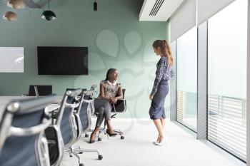 Casually Dressed Businesswomen Having Informal Meeting In Modern Boardroom
