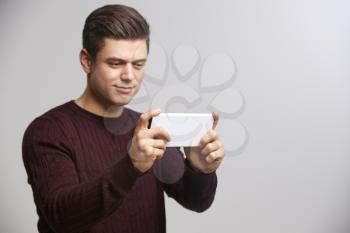 Young white man taking a selfie with his smartphone