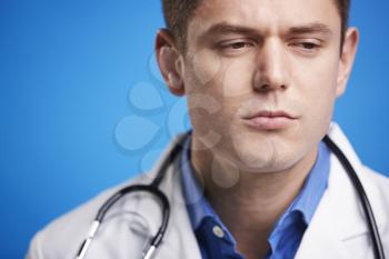 Stressed white male doctor in a lab coat with stethoscope