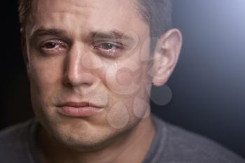 Close up portrait of crying young white man looking away