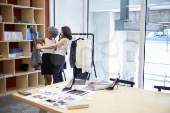 Two women discussing clothes in a creative media office