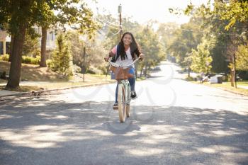 Girl Riding Bike Along Street To School