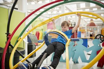 Young white boy in science centre using human gyroscope