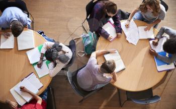 Overhead Shot Of High School Pupils In Group Study Around Tables