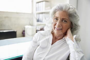 Professional senior white woman in office looking to camera