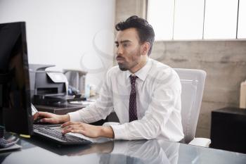 Young Hispanic businessman using computer in an office