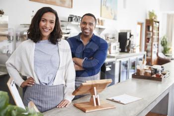 Mixed race couple behind the counter at their coffee shop