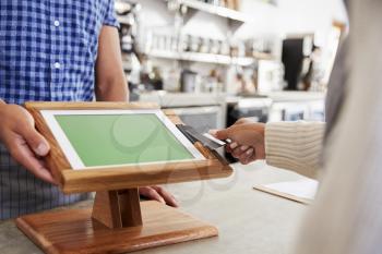 Woman making contactless card payment at a cafe, close up