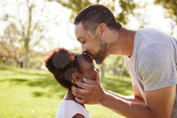 Close Up Of Father Kissing Daughter In Park