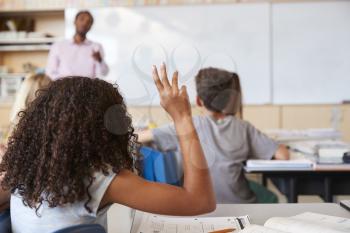 Girl raising hand to answer in an elementary school class