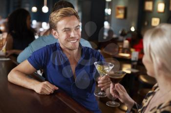 Couple On Date Making Toast Sitting At Bar Counter