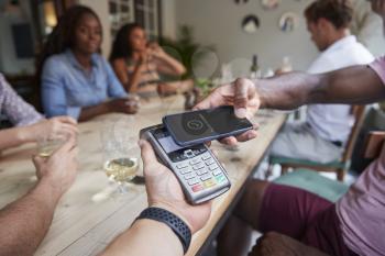 Close Up Of Customer In Restaurant Paying Bill With Contactless Phone App