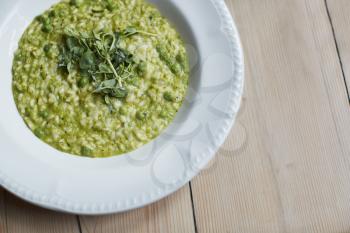 Overhead Shot Of Dish Of Pea And Mint Risotto On Wooden Restaurant Table