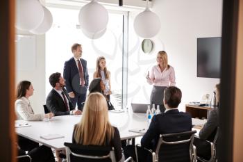 Mature Businesswoman Addressing Group Meeting Around Table At Graduate Recruitment Assessment Day