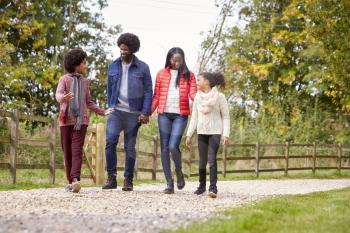 Mixed race family walking together on a country path, low angle