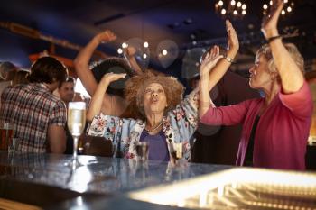 Female Senior Friends Dancing In Bar Together