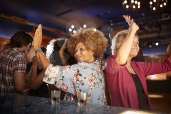 Female Senior Friends Dancing In Bar Together