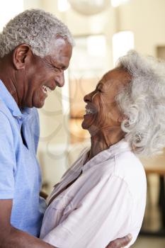 Profile Shot Loving Senior Couple Hugging At Home Together