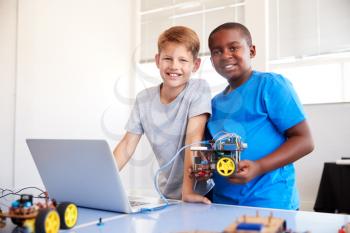 Portrait Of Two Male Students Building And Programing Robot Vehicle In School Computer Coding Class