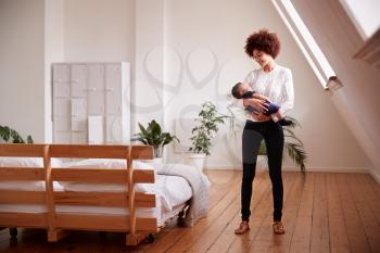 Loving Mother Holding Newborn Baby At Home In Loft Apartment