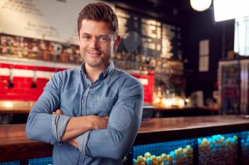 Portrait Of Male Bar Owner Standing By Counter