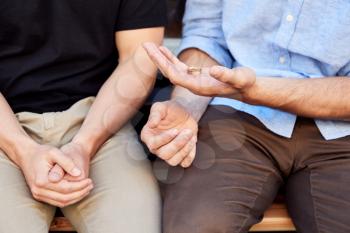 Close Up Of Man Proposing To Male Partner With Ring