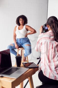 Model Posing For Female Photographer In Studio Portrait Session