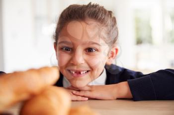 Mischievous Girl Wearing School Uniform Taking Croissant From Kitchen Counter