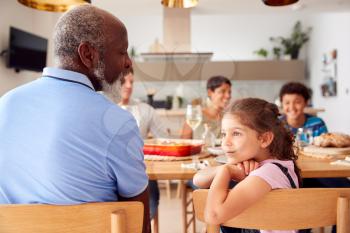 Multi-Generation Mixed Race Family Eating Meal Around Table At Home Together