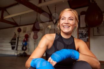 Portrait Of Female Boxer With Protective Wraps On Hands Training In Gym