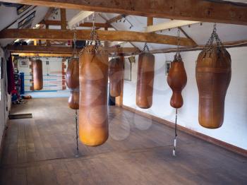 Empty Boxing Training Gym With Old Fashioned Leather Punch Bags