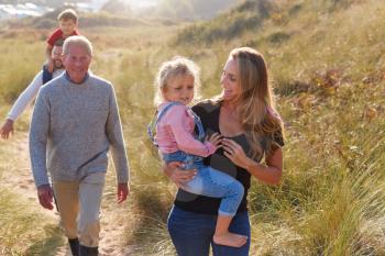 Multi-Generation Family Walking Along Path Through Sand Dunes Together