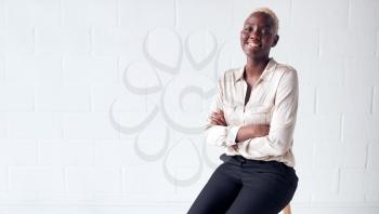 Portrait Of Smiling Young Businesswoman Standing Against White Studio Wall