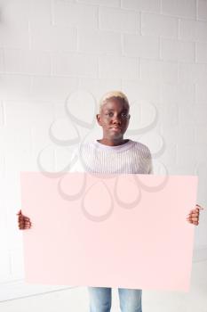 Happy Young Woman Holding Blank Pink Card With Copy Space Standing Against White Studio Wall