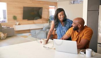 African American Couple Using Laptop To Check Finances At Home
