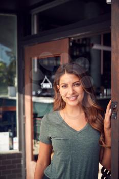 Portrait Of Female Owner Of Start Up Coffee Shop Or Restaurant Standing In Doorway