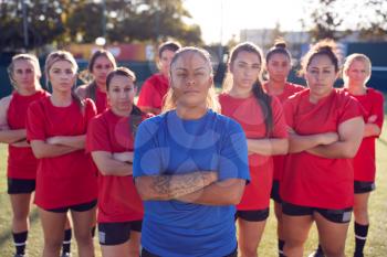 Portrait Of Womens Football Team With Manager Training For Soccer Match On Outdoor Astro Turf Pitch