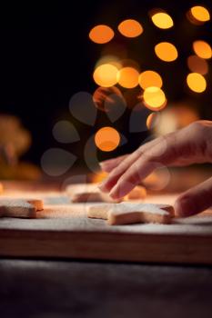 Womans Hand Reaches For Freshly Baked Star Shaped Christmas Cookies On Board Dusted With Icing Sugar