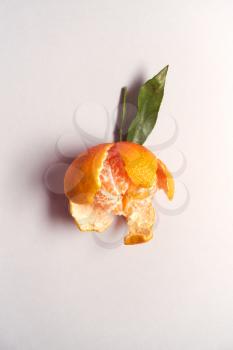 Overhead View Of Freshly Peeled Satsuma With Leaf On White Background