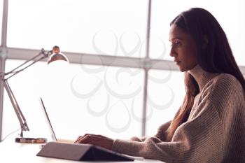 Businesswoman Working On Laptop At Desk In Modern Office