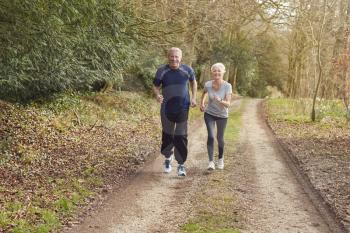Senior Couple Exercising In Autumn Countryside During Covid 19 Lockdown
