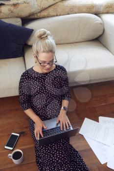 Businesswoman Sitting On Floor With Laptop Working From Home In Pandemic Lockdown