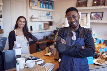 Portrait Of Smiling Couple Running Coffee Shop Together Standing Behind Counter