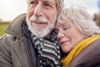Close Up Of Loving Senior Couple Enjoying Autumn Or Winter Walk Through Park Together