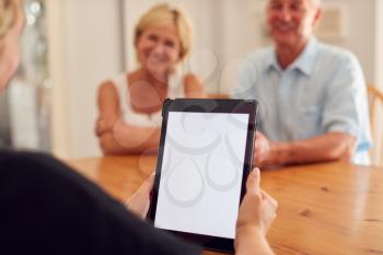 Close Up On Blank Screen Of Digital Tablet As Retired Couple Meeting With Financial Advisor At Home