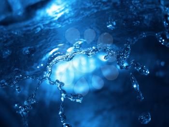 splashing water with bright blue light shining through