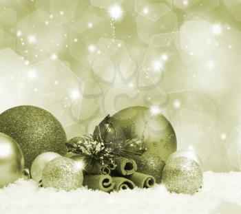 Christmas baubles in snow on gold background