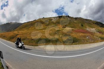 Rider on a steep mountain road turn in the Italian Alps
